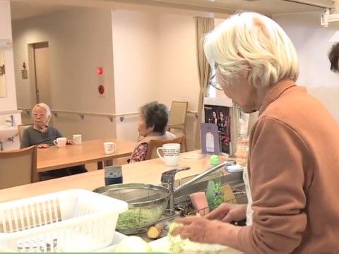 リビングに設けられたキッチンで野菜を切っている入居者様