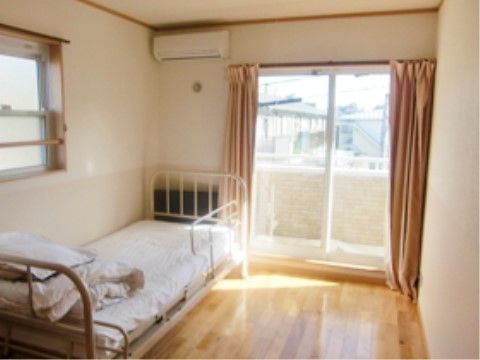 ベランダへ出ることもできる掃き出し窓のある明るい部屋である。ベッド脇にも窓が設けられているため、換気もしやすい。