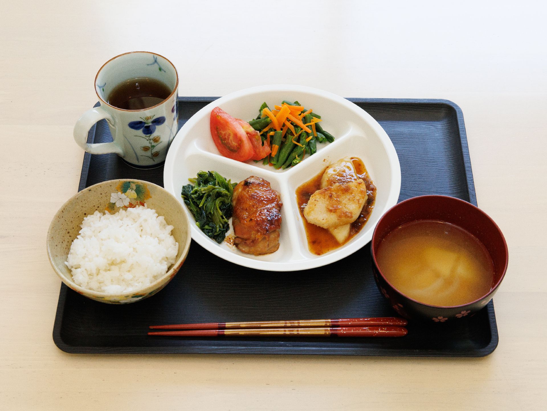 チキンや野菜、ご飯と味噌汁がセットになった食事