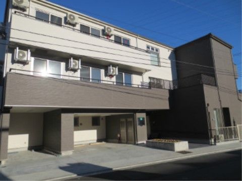 建物は白い部分とグレーの部分とに色分けされており、シンプルなデザインである。2階と3階にはベランダが設けられている。