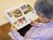 居住者様が椅子に座って、読書をしている様子。本には、お寺や食事の写真がいくつも載っており、記事が書かれている。