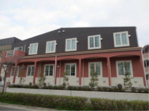 施設は、外壁が１階がピンク色２階が黒色のツートンカラーの建物