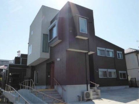 近隣住宅に馴染むようデザインされた２階建ての施設建物