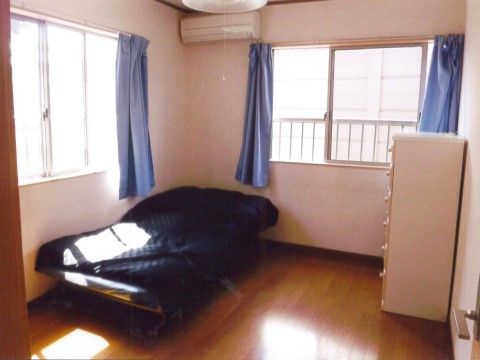 ワンルームタイプの居室である。2面に窓があり、日当たりも良好で明るい。床面はフローリングで段差がない。エアコンも完備している。