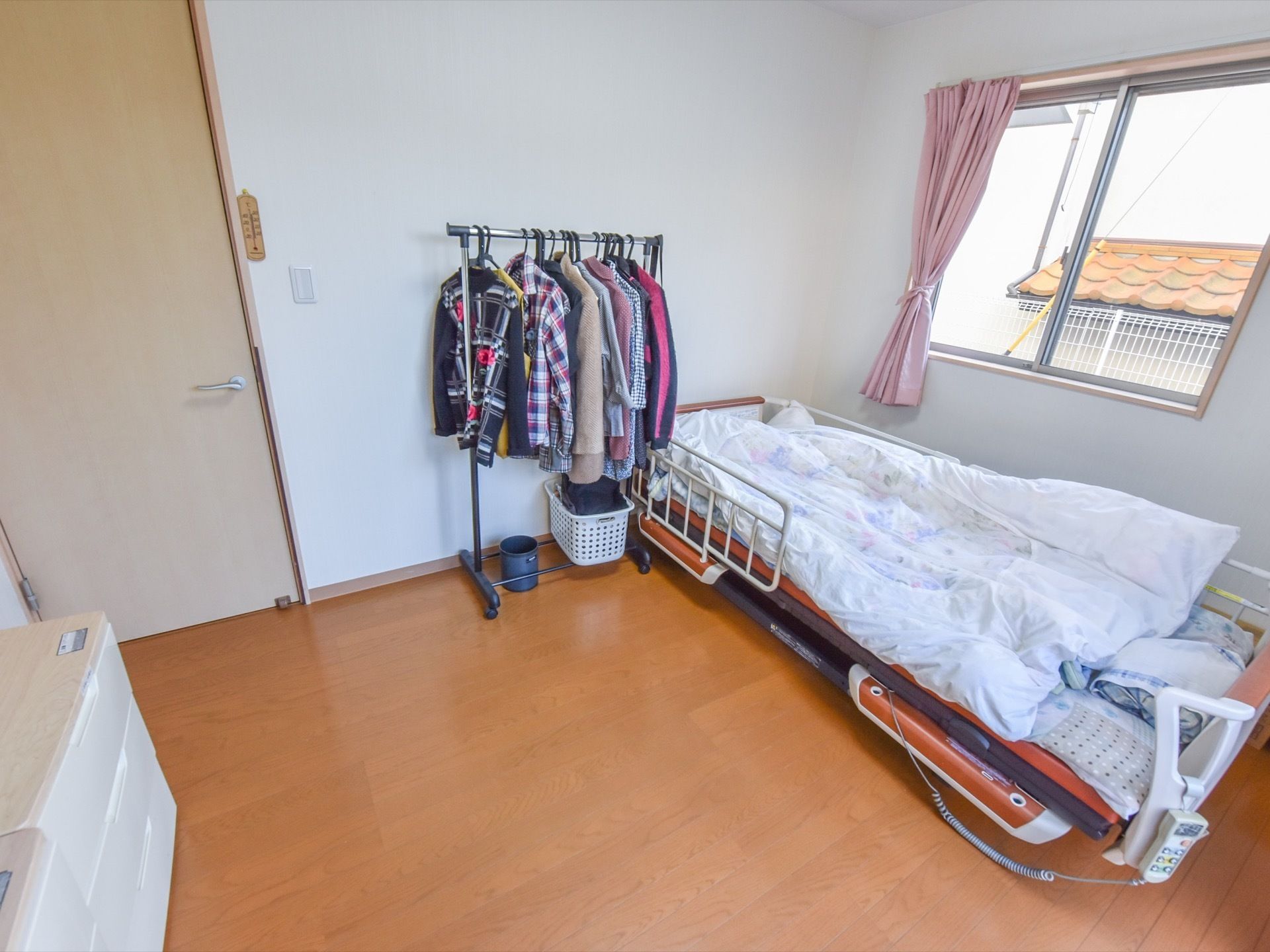 部屋はフローリングになっているので、車椅子での移動にも問題はない。タンスやハンガーラックも備えてあるので、収納にも十分対応が可能。