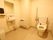 手洗い場が備えつけられた広々としたトイレで、ペーパータオルが用意されている。壁には鏡や暖房が設置されている。