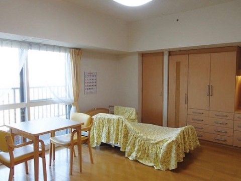 収納家具や介護ベッド、２人掛けテーブルが完備されている広々とした居室