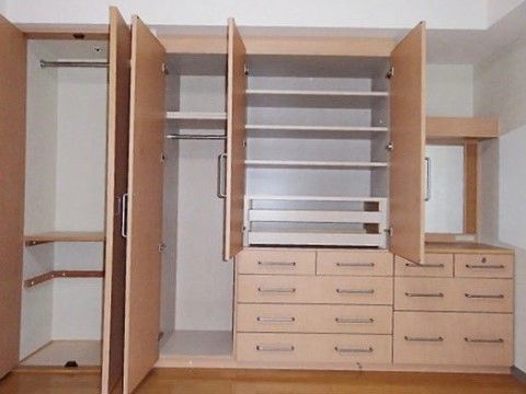 木目調の板が貼られたクローゼットが壁に建て付けられている。衣類をハンガーラックにかけたり、引き出しの中に畳んで仕舞ったりできる。
