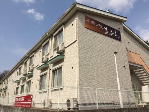 白いフェンスで囲まれた、外階段が設置されている建物
