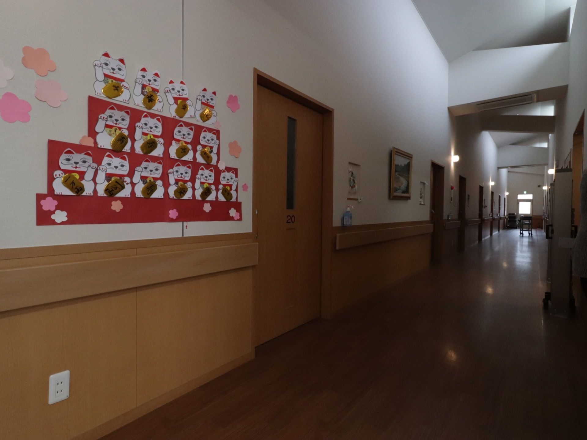白い壁に木目調の床と扉で統一している。壁には額物に入った絵画のほか、たくさんの招き猫の絵が雛壇のように飾られている。