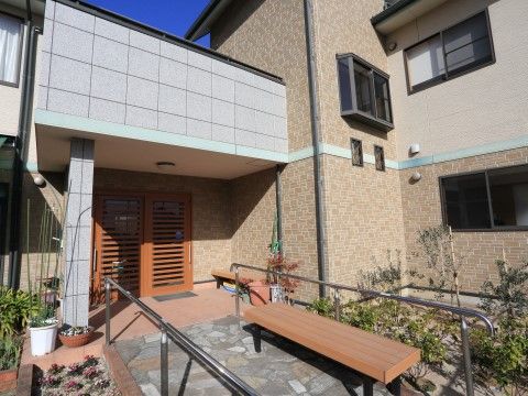 「グループホームひなた」の外観。玄関周りに緑を配している。