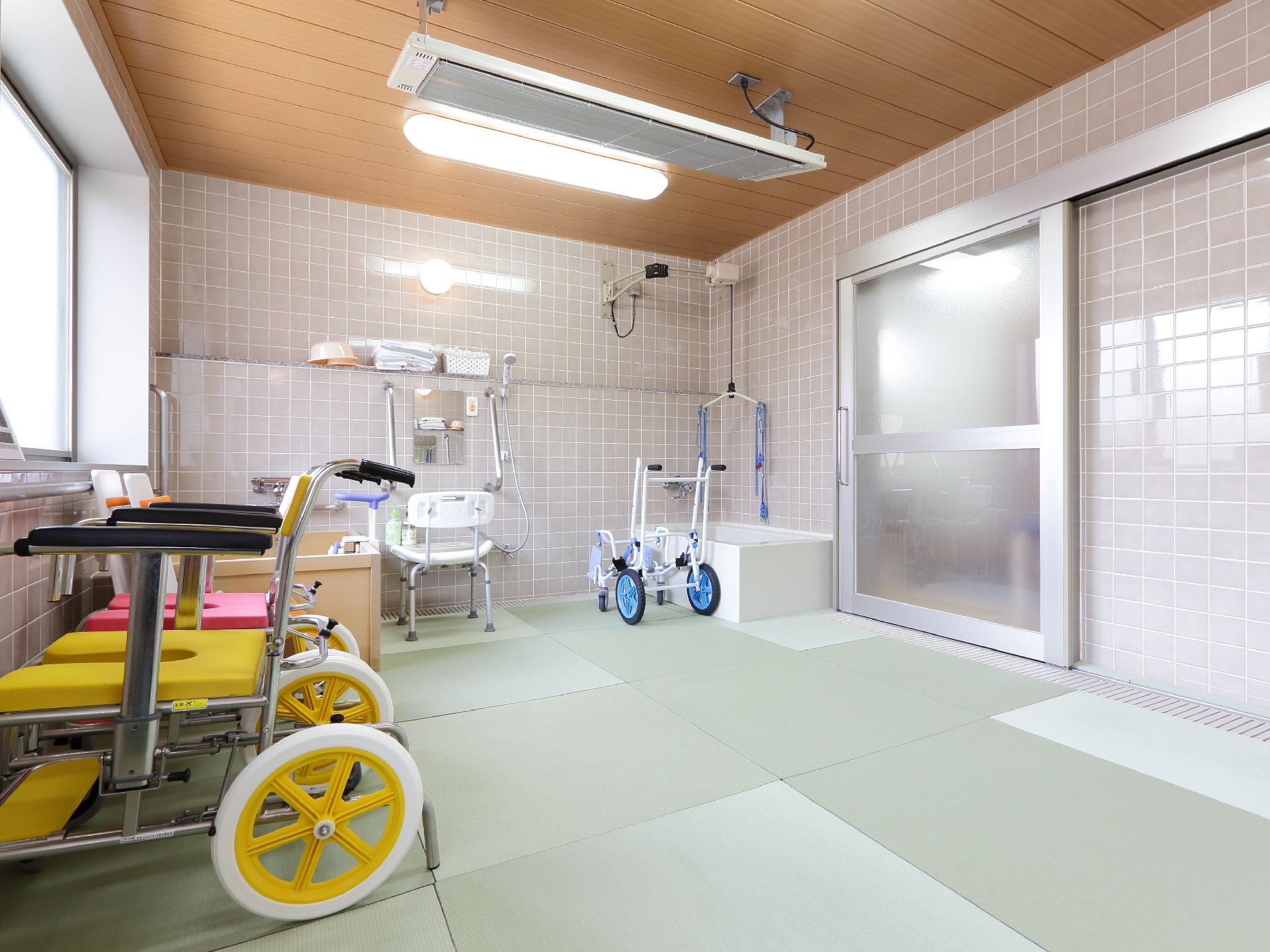 浴室の入り口扉は非常に大きく、開放的なつくりとなっている。床のタイルは凹凸が少なく、滑りにくいような工夫がされている。