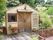 施設の庭に建てられた小さな小屋。中央には、アイアンの取っ手が付いた大きな木の扉がある。全体的にアンティーク調でヨーロッパ風。
