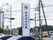 道路わきに施設の案内用看板が設置されている。施設名や電話番号、訪問診療の在宅診療所の記載もある。