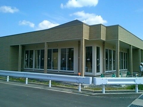 平屋建ての建物で、壁の色は白色およびベージュの配色である。壁面にはガラス引き戸があり、屋外スペースには屋根が設けられている。