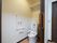 居室に設けられたトイレは広いスペースがあり、奥の壁には収納棚が設置されている。壁には、手すりも取りつけられている。
