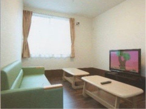 スペースの床はフローリングで、壁には大きな窓が設けられている。床の上には大型テレビ、テーブル、ソファが設置されている。