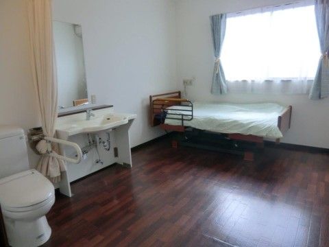 広々とした個室の居住空間は大きな窓からの日差しで明るく快適であり、車椅子に座ったままで使いやすい仕様の洗面台とトイレが完備されている。