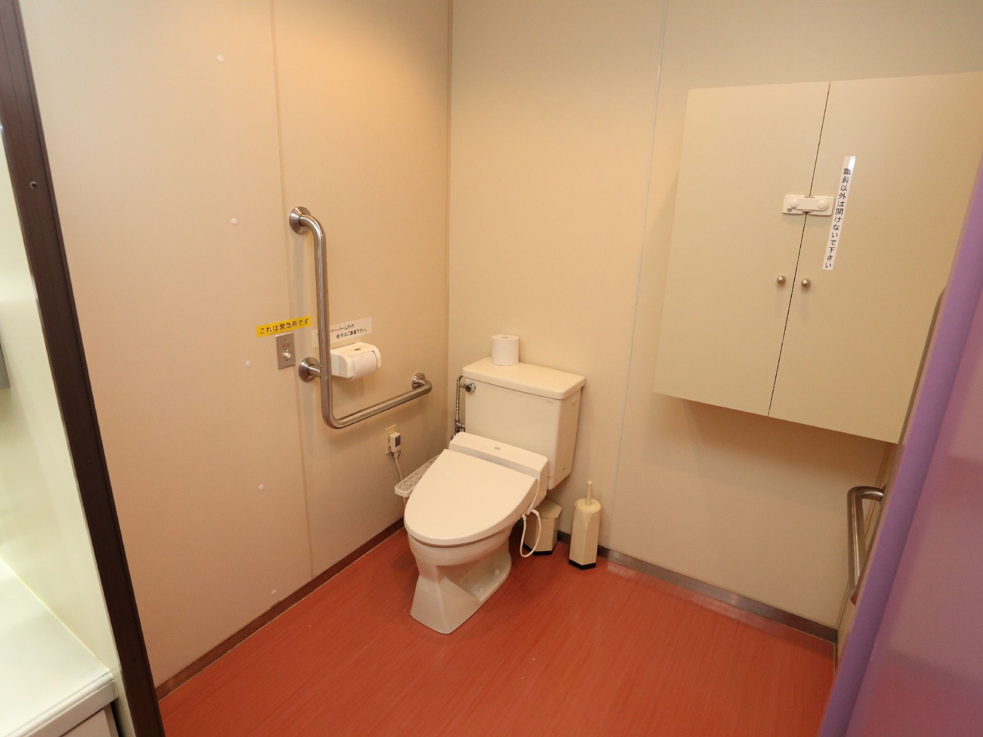 トイレには、手すりが付いており、温水洗浄便座も設けられている。個室内は広いスペースになっており、床はフラットである。