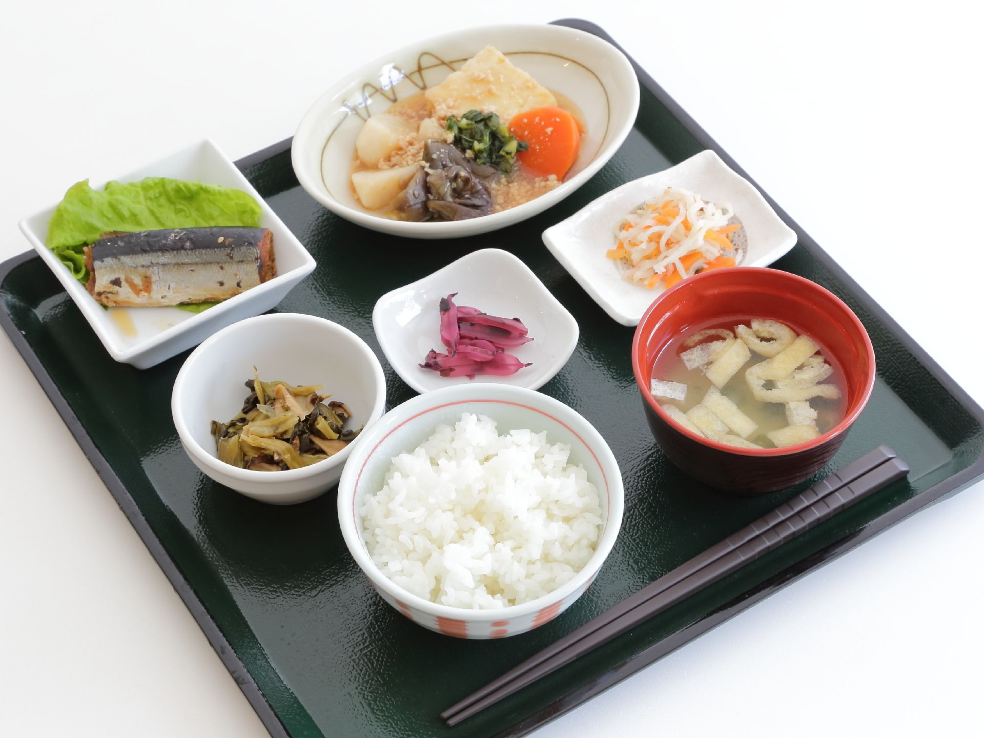 四角いトレーのうえにご飯、味噌汁、お漬物、酢の物、魚、煮物の小鉢が盛り付けられている。色どりもよく、栄養管理も考えれている。