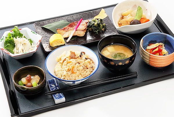 炊き込みご飯と味噌汁、焼き魚と煮物のセット