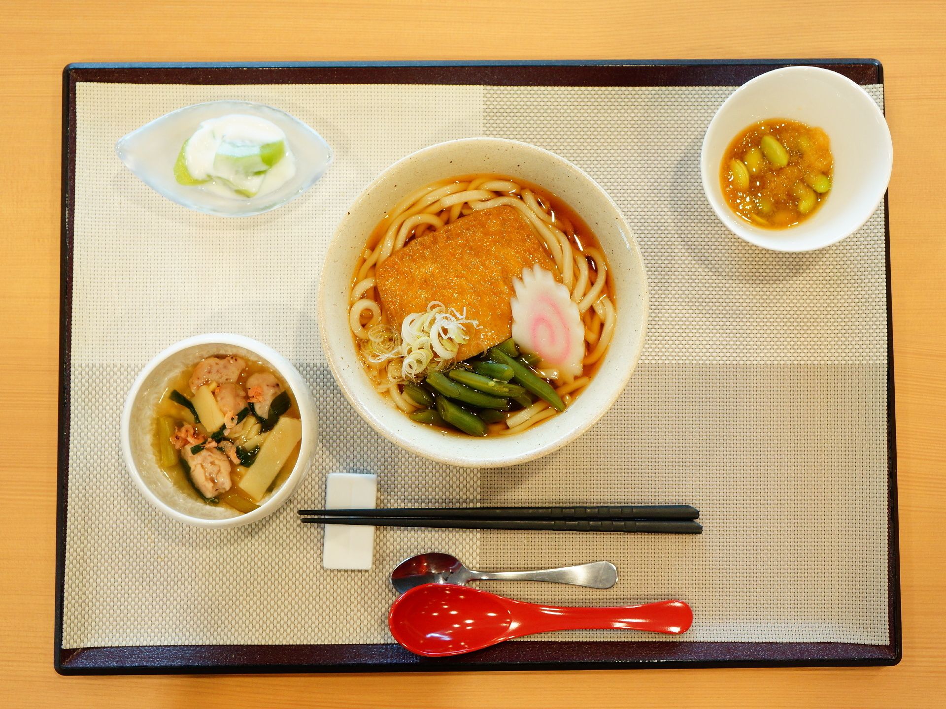食事メニューはブラウンのトレーの上にランチョンマットをセットして並べられる。箸置きは陶器製でシンプルなデザインである。
