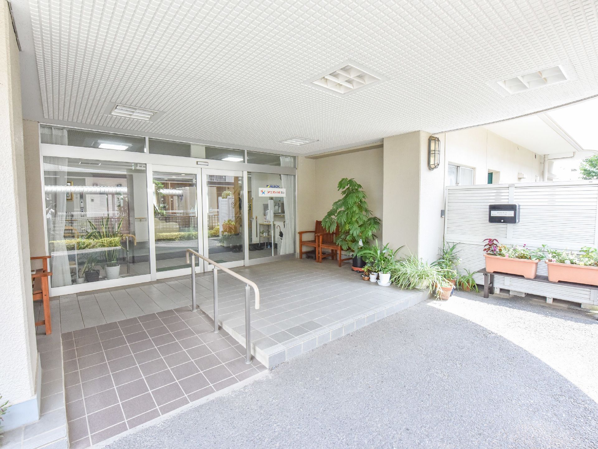 手前左側はスロープになっており、車椅子使用者が楽に通過できる。右側はプランターなどの植物が置かれている。