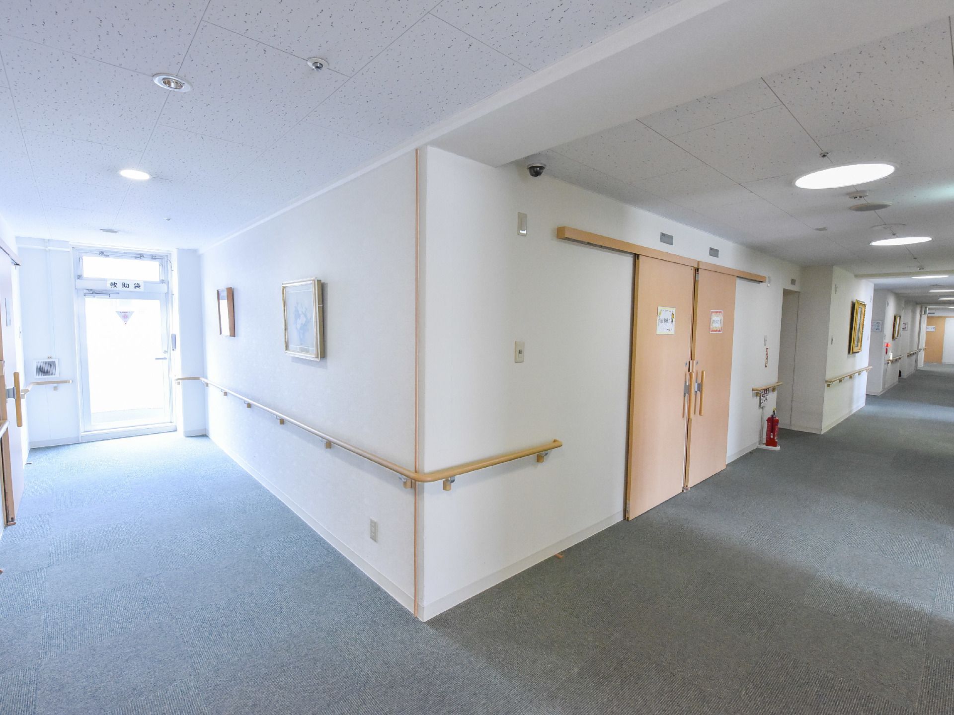 共用廊下の途中には初期消火に有効な消火器が設置してある。向かって左側は非難する際の非常用のドアになっている。