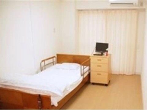 天井まである大きな窓に、白いカーテンが取り付けられている居室