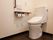居室には、洋式トイレが完備されている。壁には手すり、呼び出しボタン、洗浄機能付きパネルが取り付けられている。