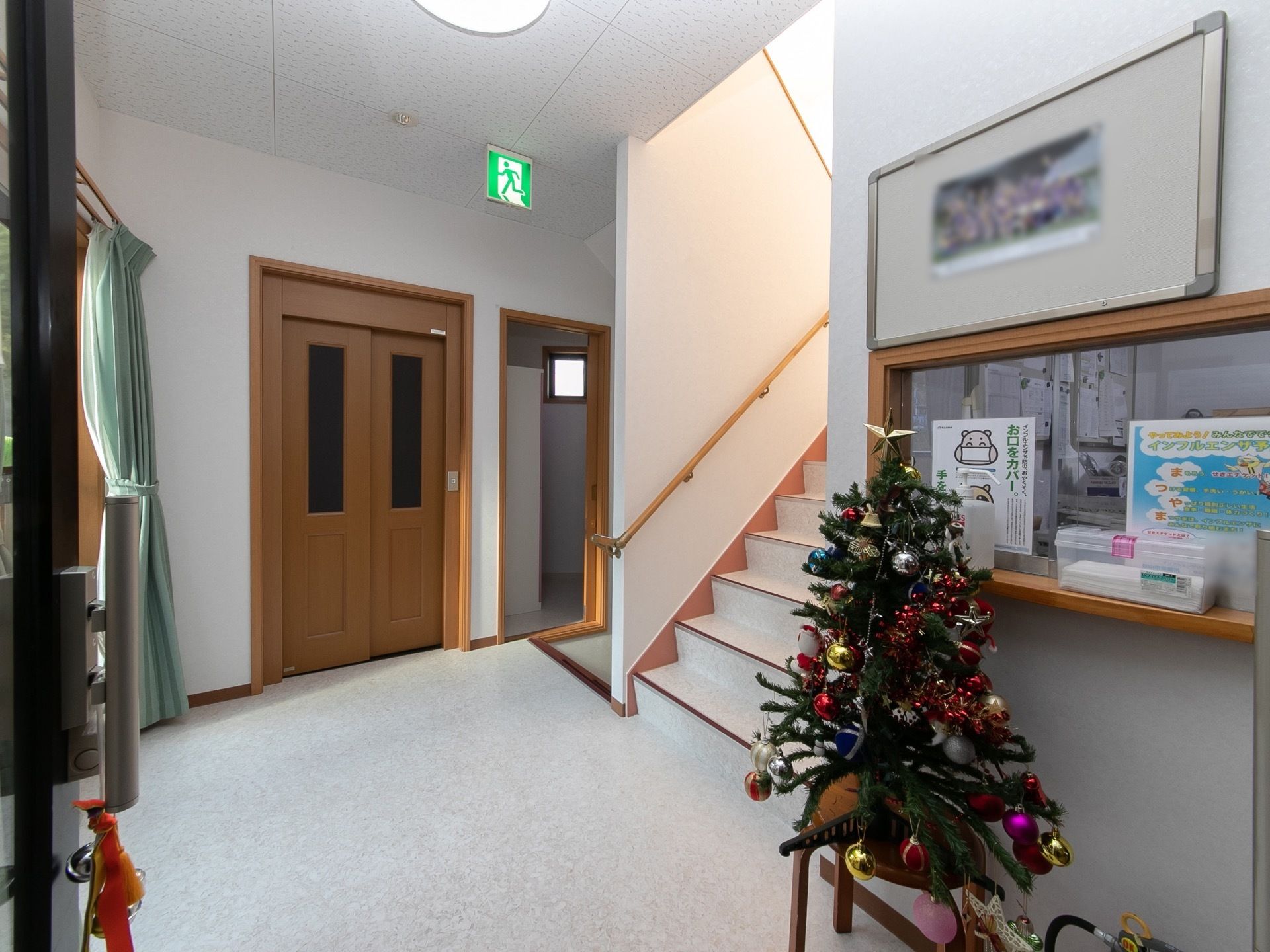 木のぬくもりが感じられるエレベーターが１基設置されている。スタッフルームの前には、クリスマスツリーが飾られている。