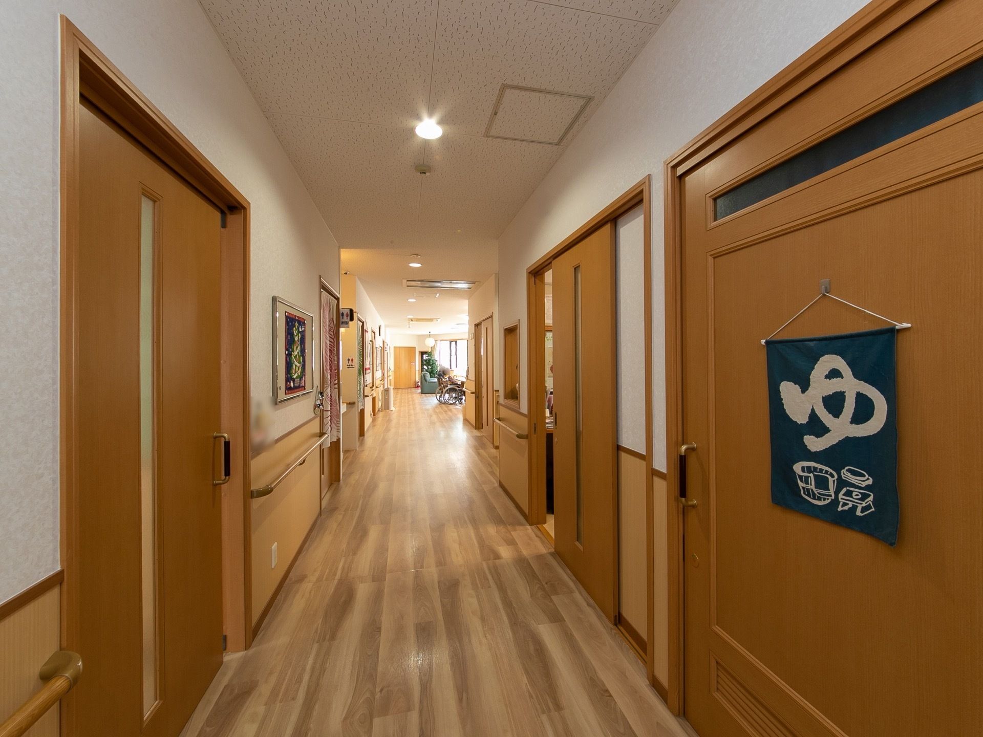各部屋はスライド式のドアとなっており、手前の扉にはお風呂の暖簾が掛けられている。通路途中にはお手洗いがある。