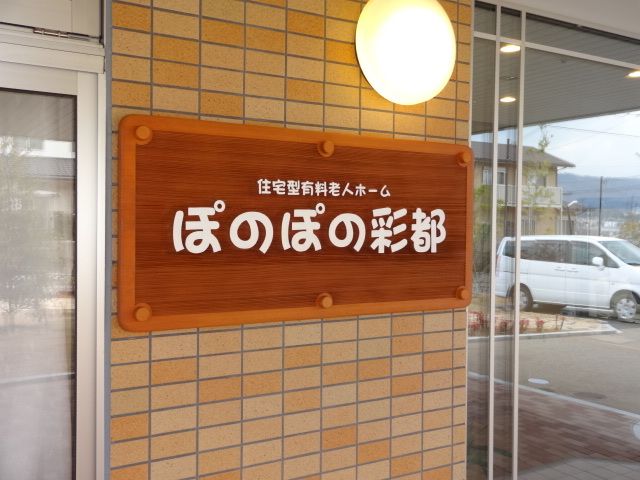 レンガ張りの壁に設置されている、施設名が書かれた看板