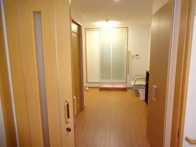 踏み台にピンクのタオルが敷かれている、浴室の入り口