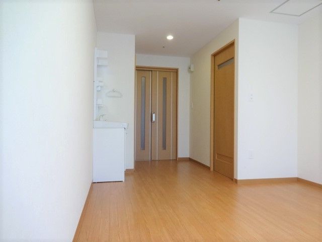 白い洗面台が備え付けられている、フローリングの居室
