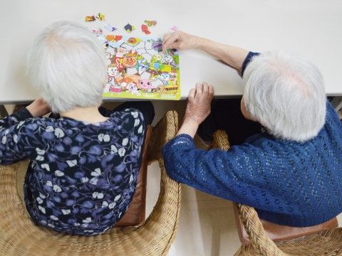 椅子に座りながらパズルを楽しんでいる２人の入居者様