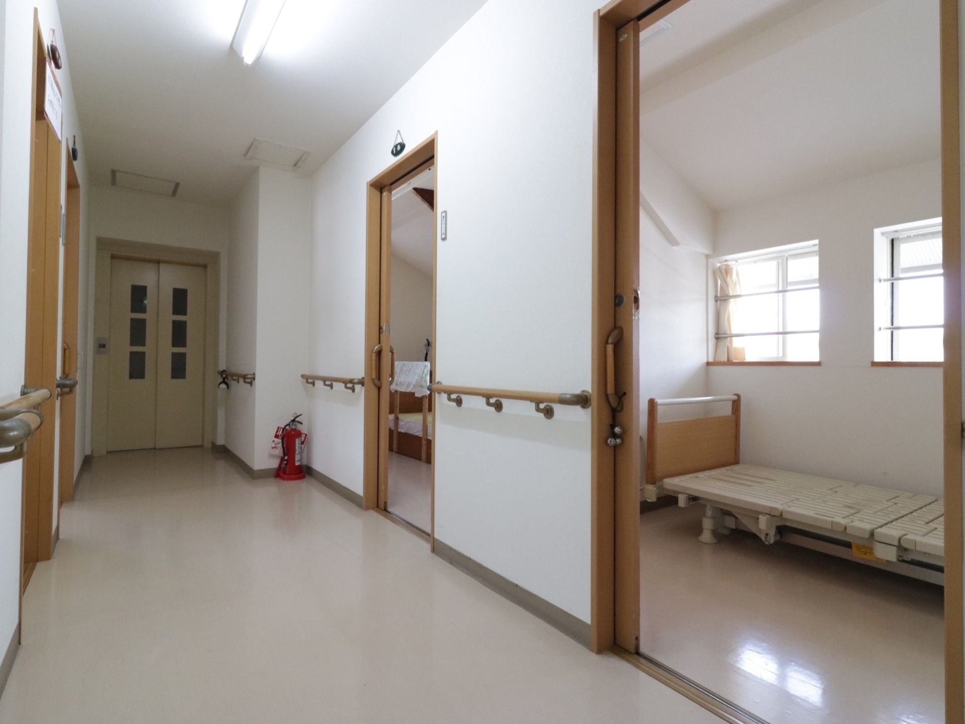 通路にはすべて手すりが取り付けてある。居室前の扉はスライド式のものが使用されている。消火器が設置されている。