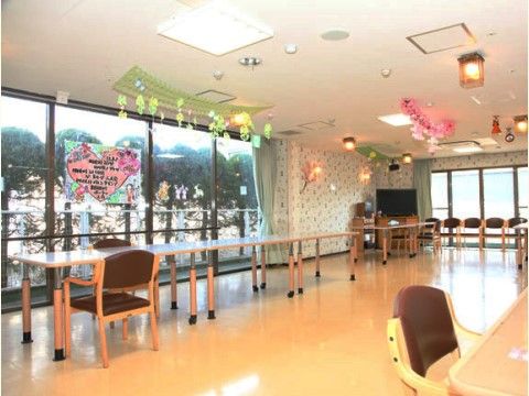 「介護付有料老人ホーム さくら本館」のリビング。明るい飾り付けがされている。