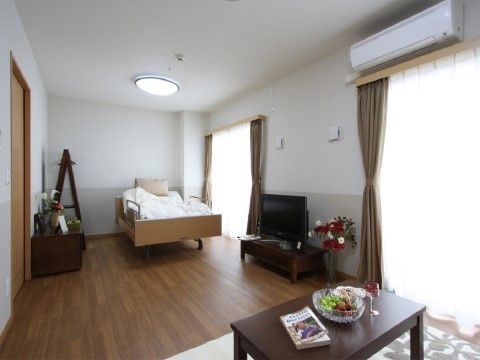 日当たりの良い居室である。介護ベッドやテレビなどの大きな家具を置いても充分なスペースのある部屋である。