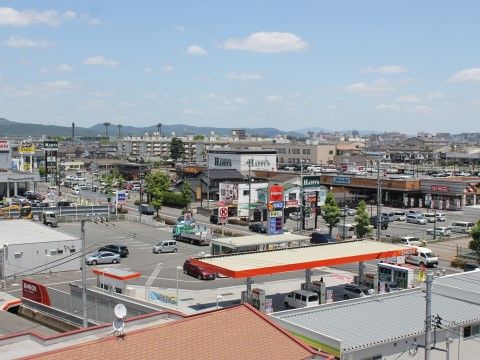 上から撮影された街並みの写真である。スーパーマーケットやガソリンスタンド、コンビニエンスストアなどが見える。