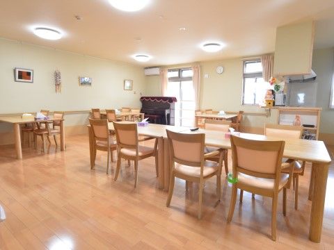 「サービス付高齢者向け住宅 ラポール樂翁館」食堂。正方形のテーブルには、均等に椅子が配置されており、共有で視聴できるテレビも用意してあります。