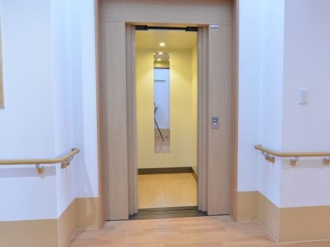 「サービス付高齢者向け住宅 ラポール樂翁館」エレベーター。壁には手摺がついています。また、エレベーター内部には鏡も付いています。