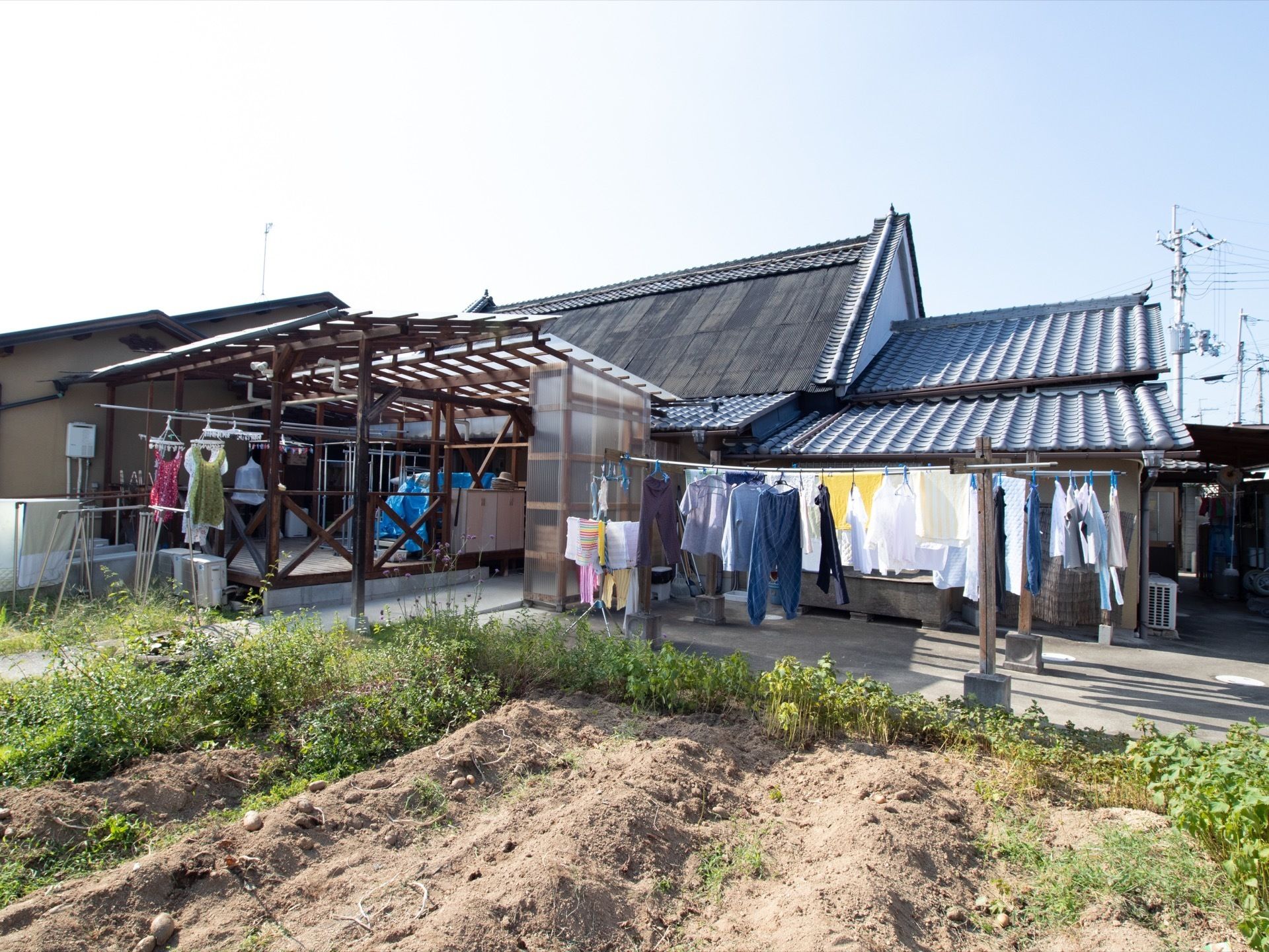 施設の敷地内に、広々とした畑が完備されている。庭やテラスには、物干し竿にたくさんの洗濯物が乾かされている。