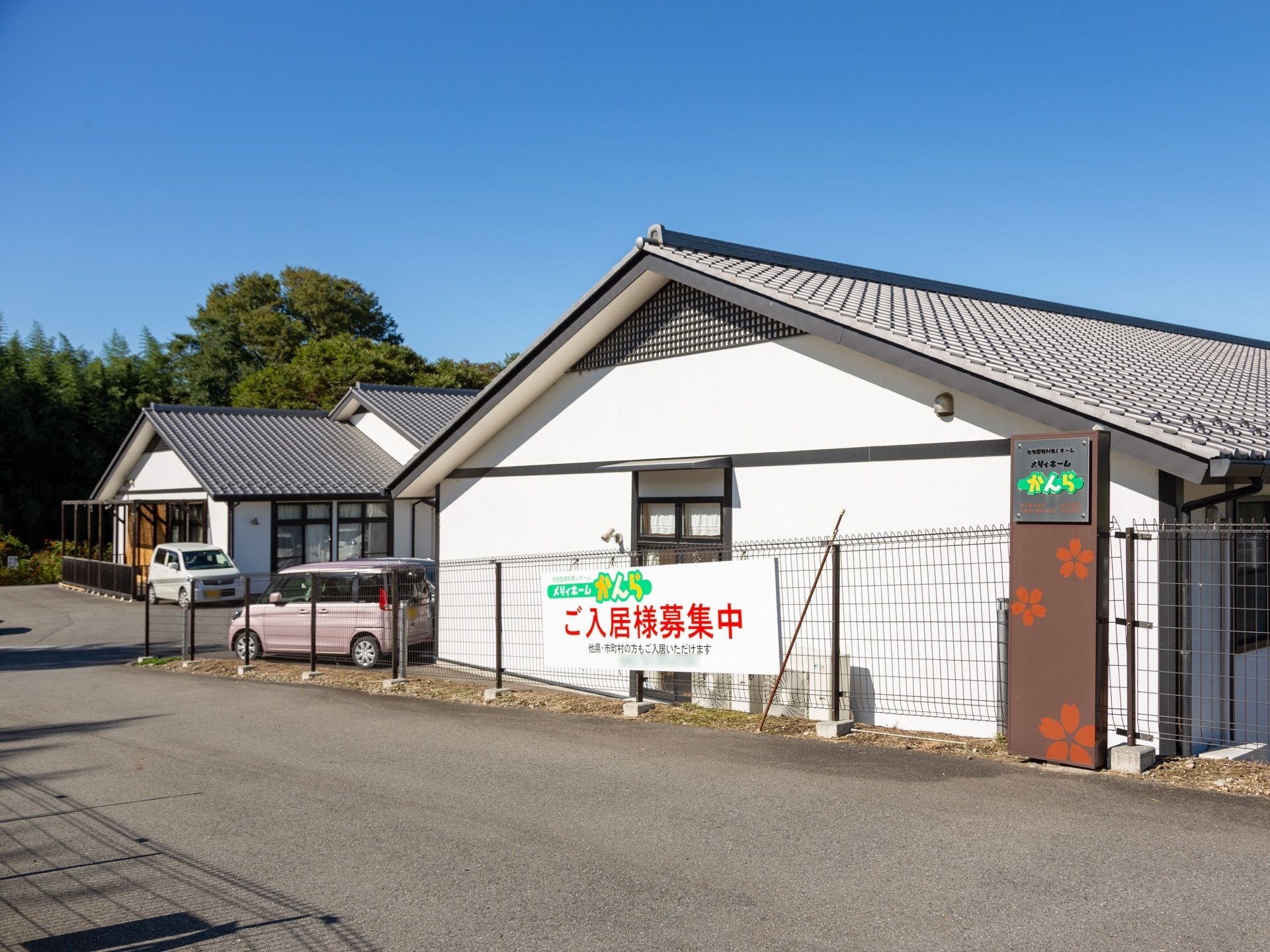 駐車場の出入口には施設の名称が印字された金属製のプレートが設置されている。黄色や黄緑色の文字で確認しやすくなっている。