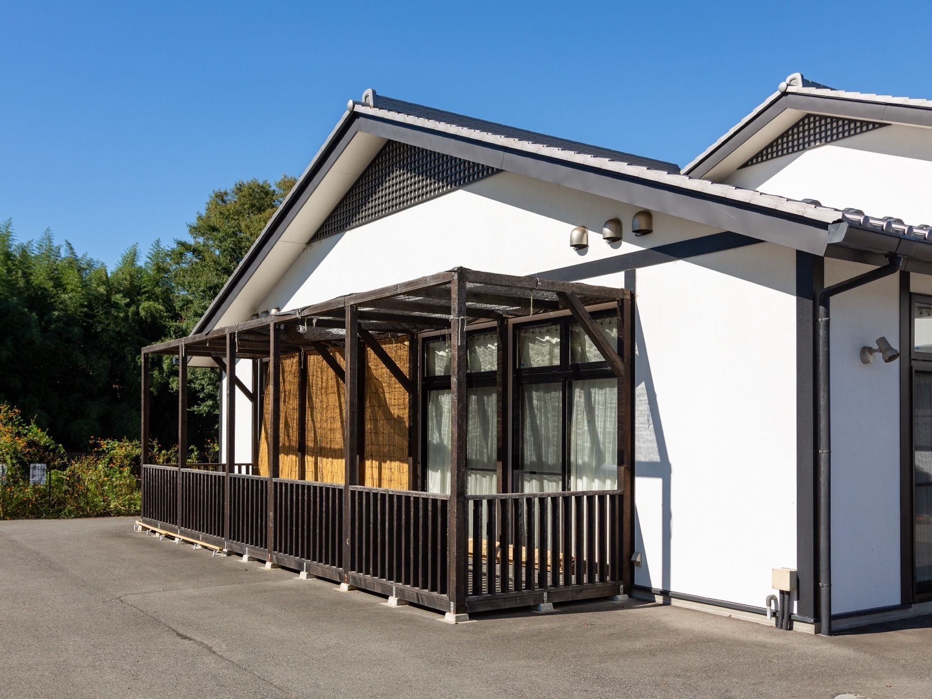 施設建物の横に設置された茶色で下が格子状になっている木製のテラス