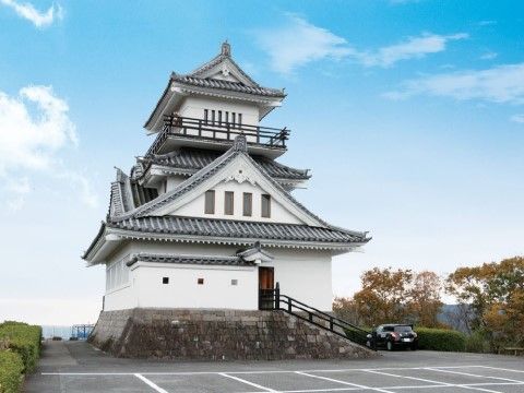 黒い手すりの付いた石段が城内へ続く山城である。遠くの山々が見渡せ、剪定された木々、整備された駐車場がある。