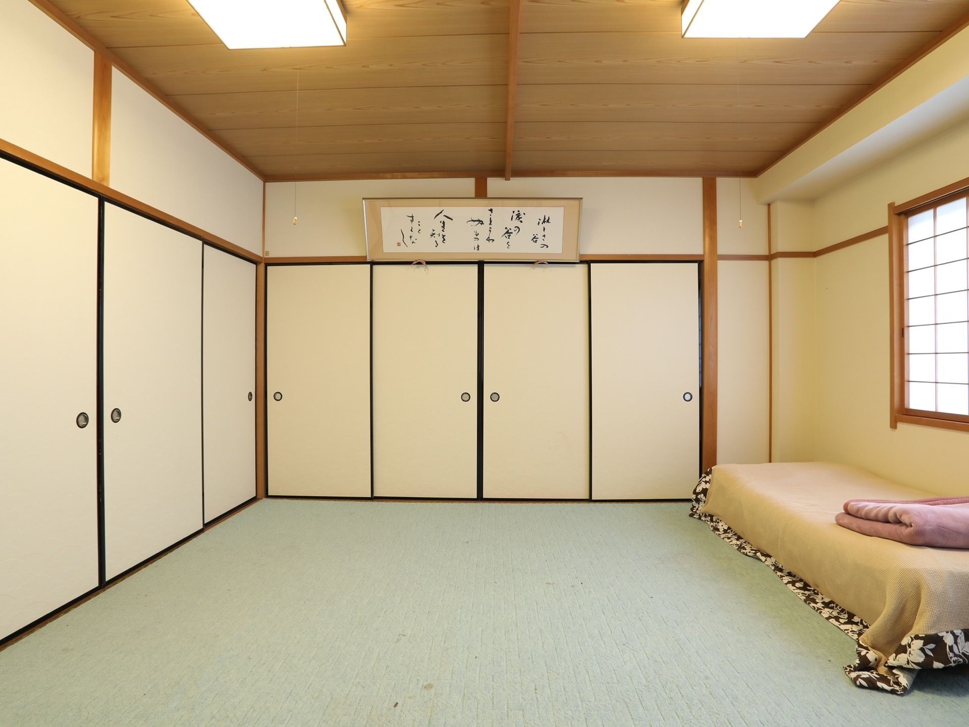 襖に囲まれた部屋に、額に収められた書画が飾られている。照明などのインテリアからも和の趣が感じられる落ち着いたスペースである。