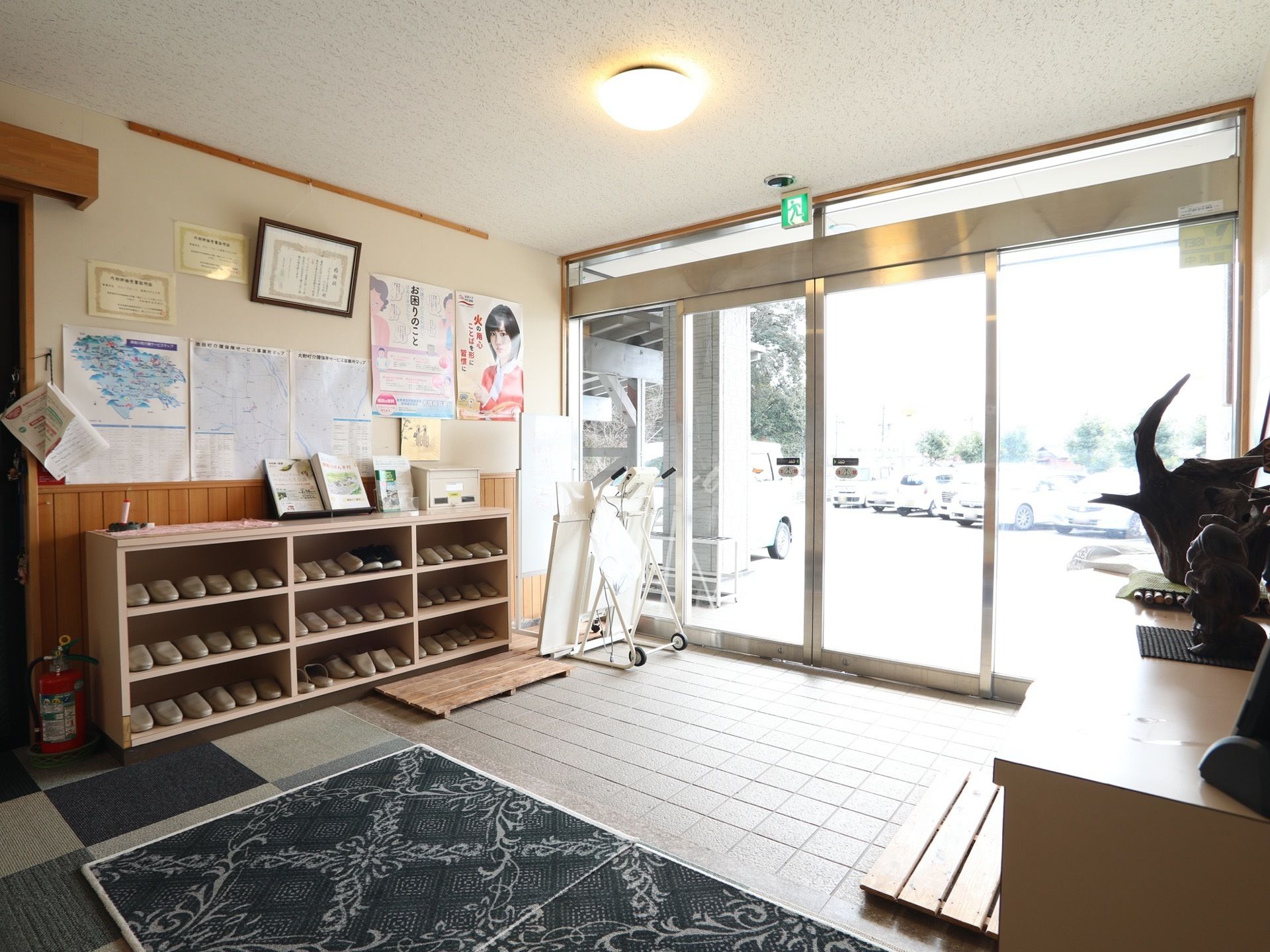 靴棚の上にはさまざまな掲示物が貼られている。施設内と玄関は段差なく設計されており、移動のしやすさに配慮されている。