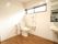天井近くの窓から屋外の光が入り、トイレ内は明るい空間である。床は移動しやすいよう、段差なく平らに設計されている。