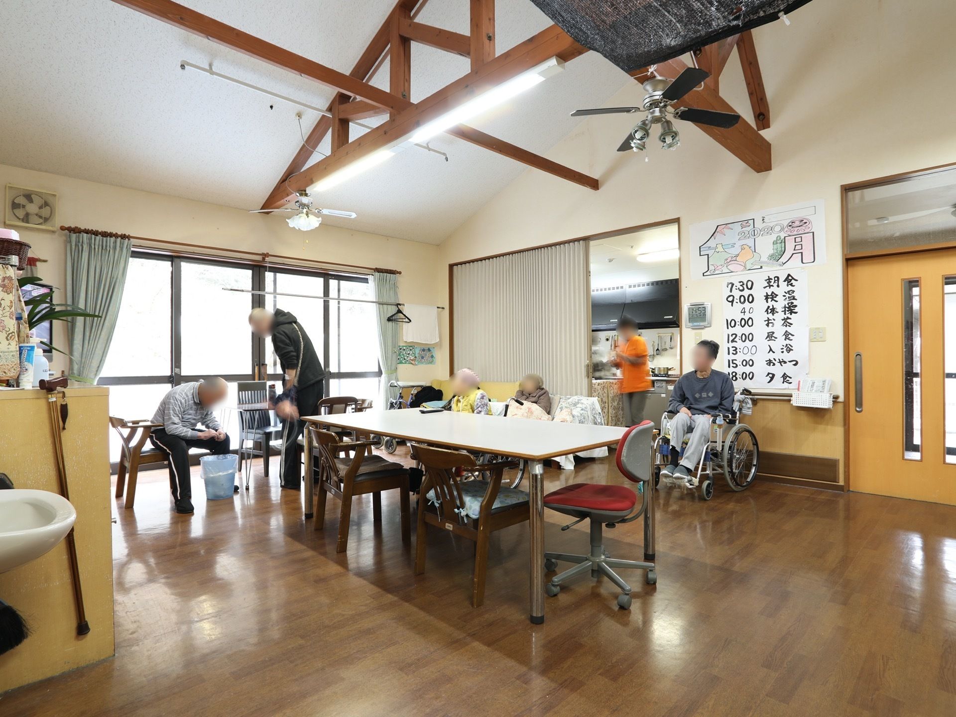 壁には一日の予定表が貼られている。キッチンスペースが併設されており、アコーディオンドアで仕切られている。